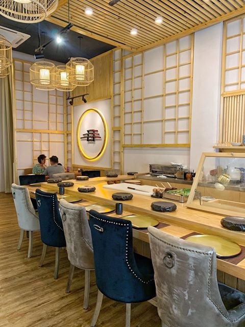Counter seats with upholstered chairs at Kazumasa